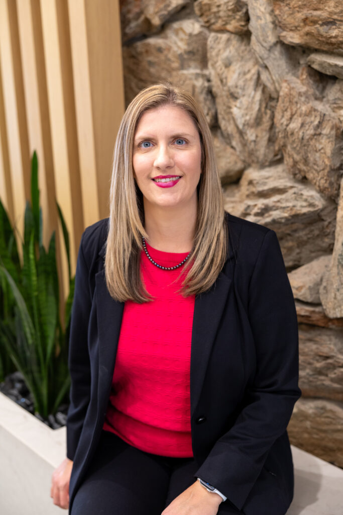 Attorney Adrianne Speas sitting in her law office lobby with plants in the background.